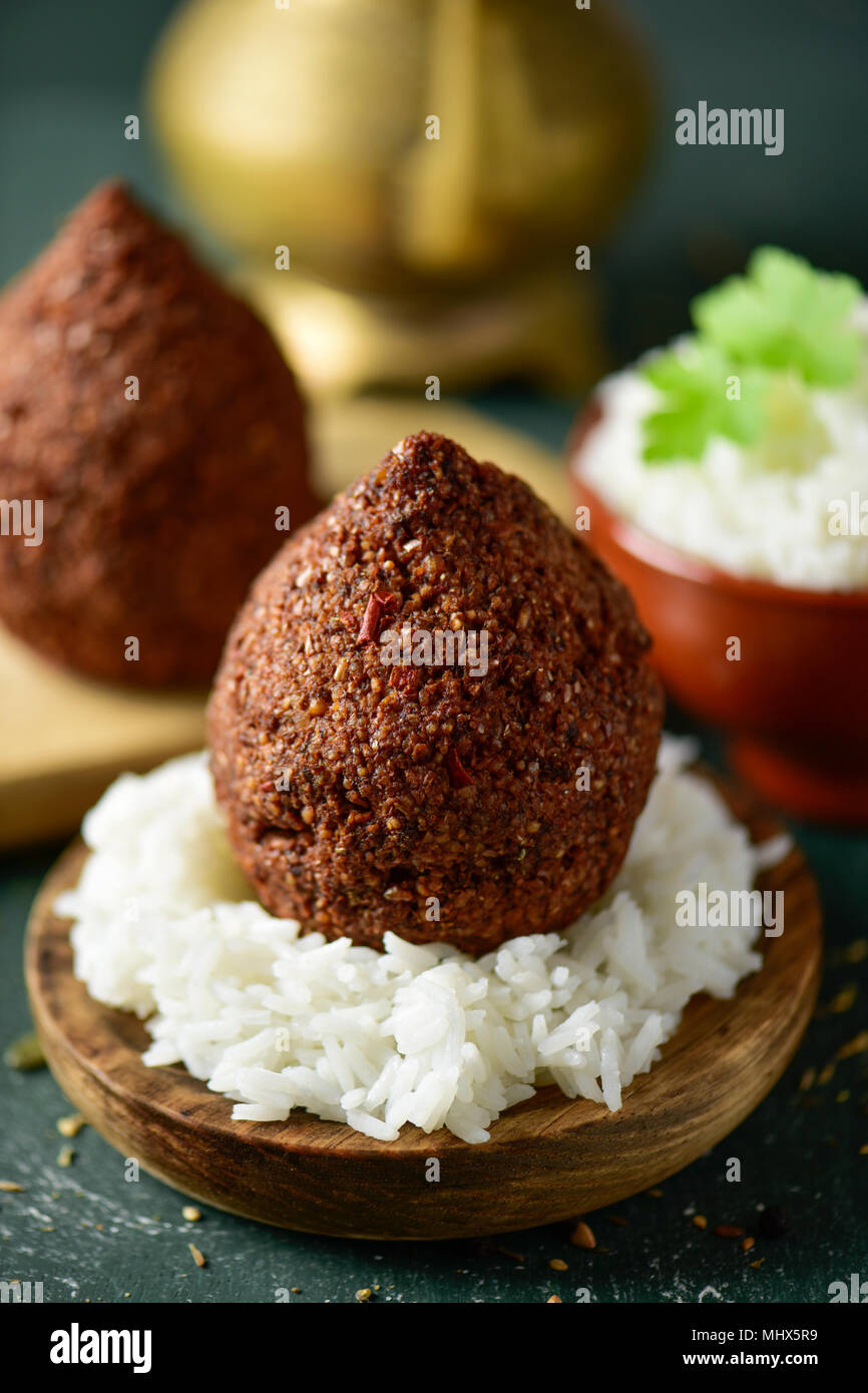kibbeh, a levantine dish, on a rustic wooden table Stock Photo