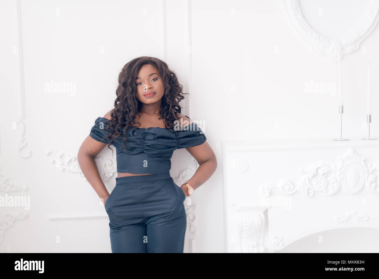 Beautiful young african american girl posing in studio, looking at ...