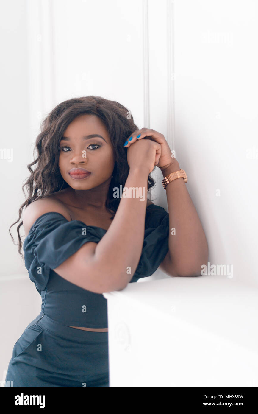Beautiful young african american girl posing in studio, looking at ...