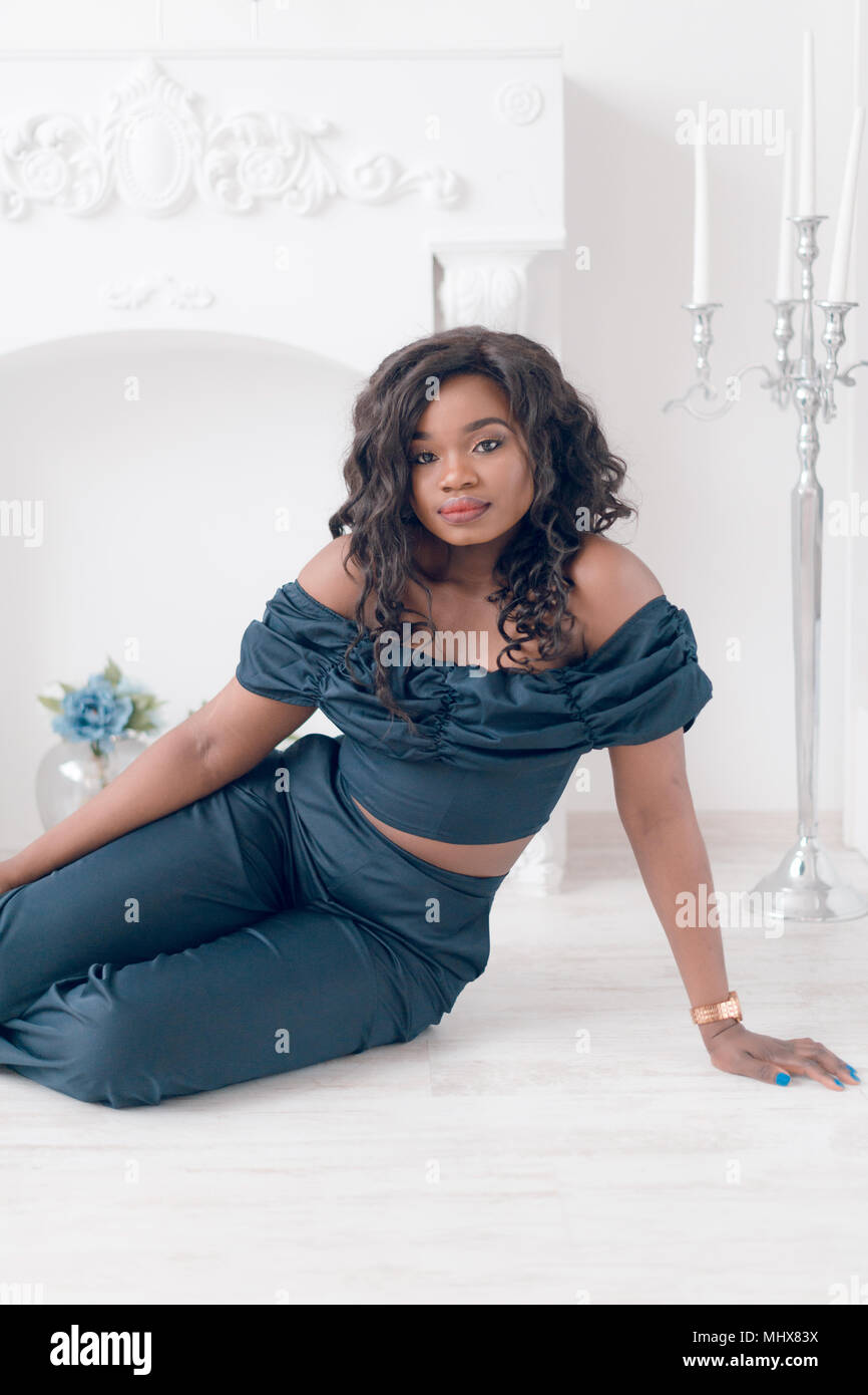 Beautiful young african american girl posing in studio, looking at ...