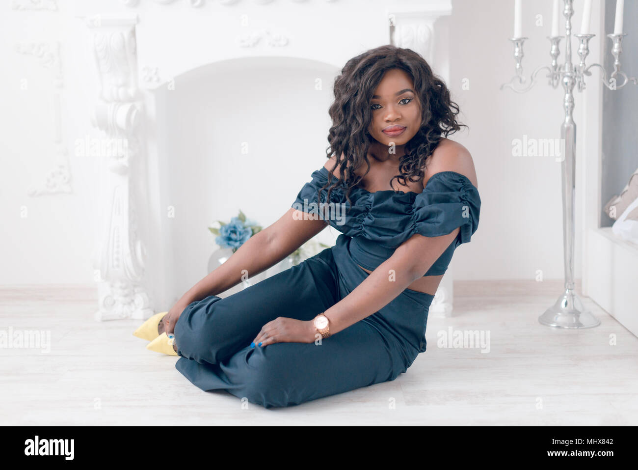Beautiful young african american girl posing in studio, looking at ...