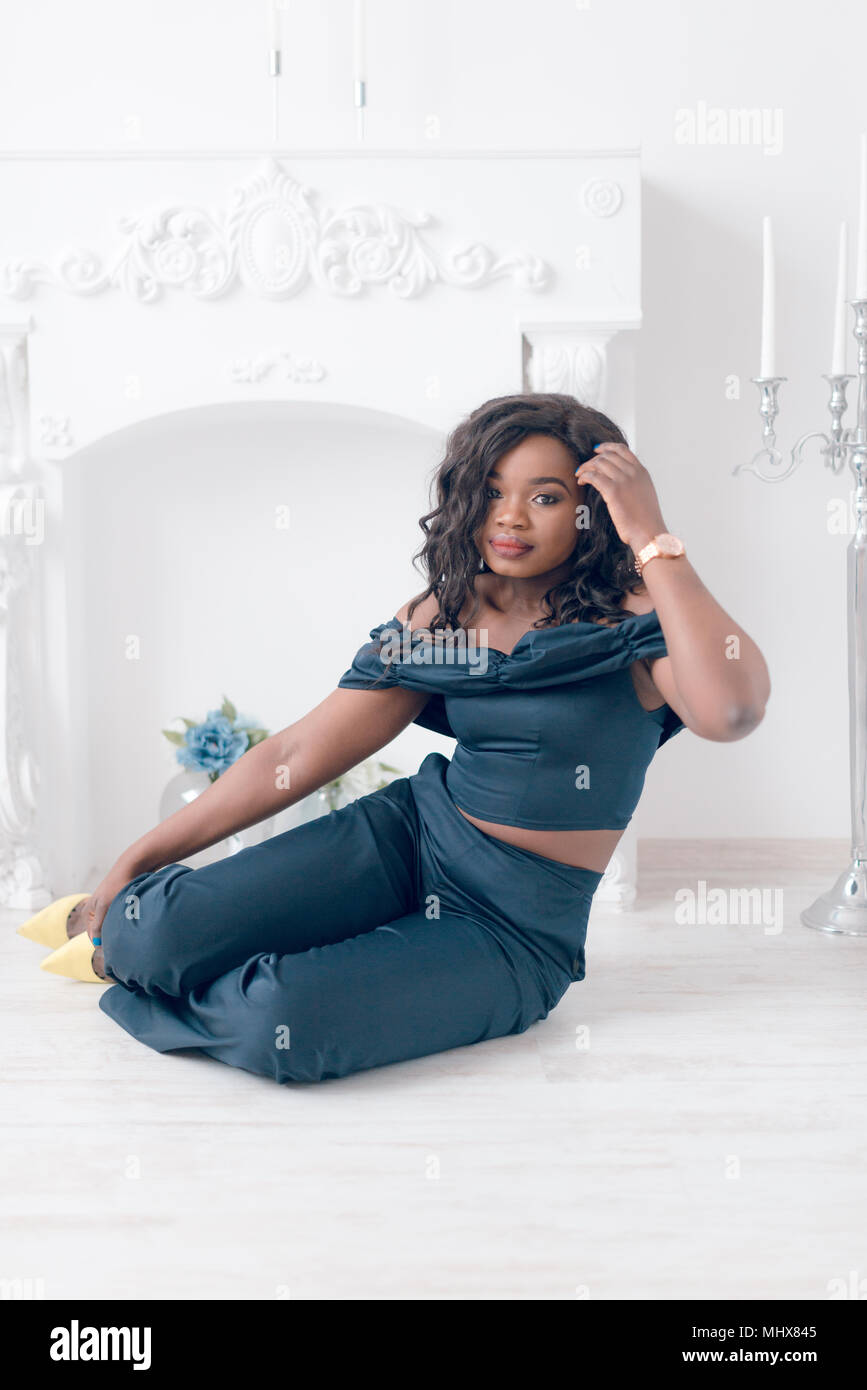 Beautiful young african american girl posing in studio, looking at ...