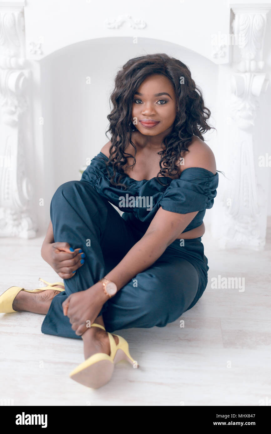 Beautiful young african american girl posing in studio, looking at ...