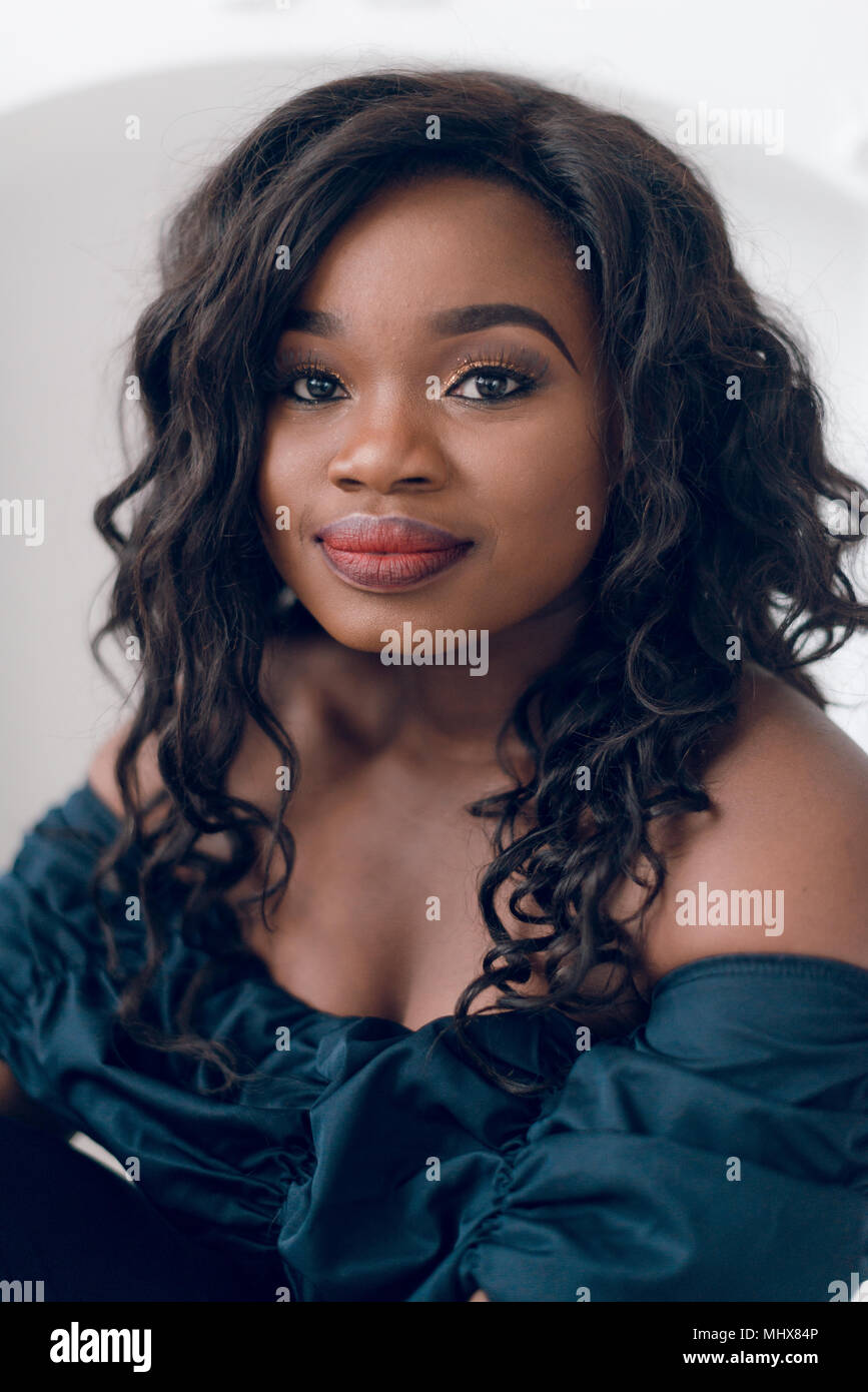 Beautiful young african american girl posing in studio, looking at ...