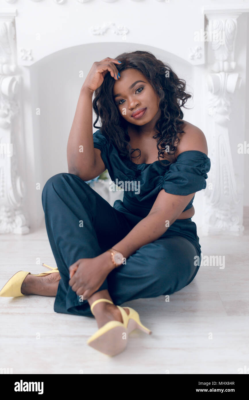 Beautiful young african american girl posing in studio, looking at ...