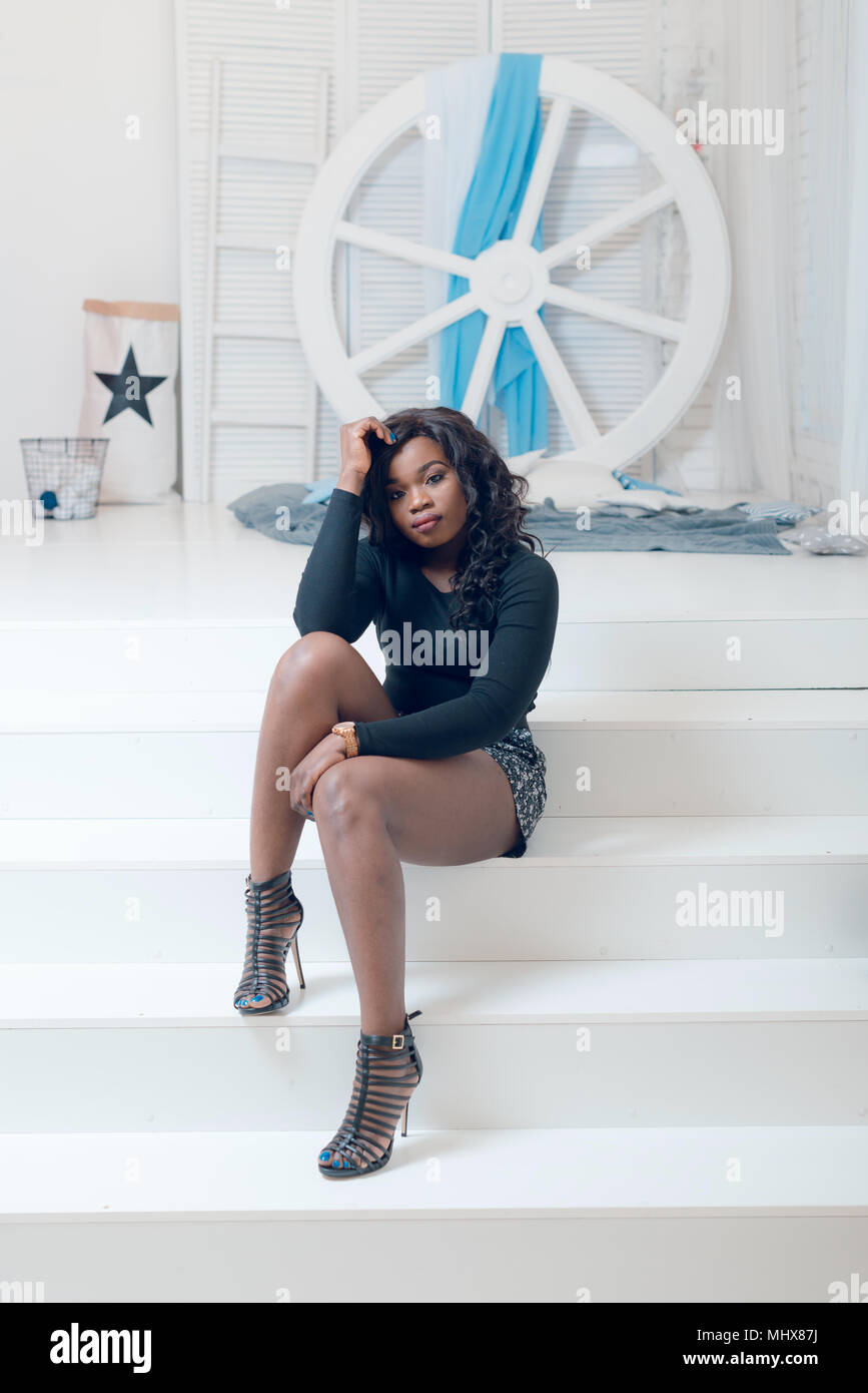Beautiful young african american girl posing in studio, looking at ...