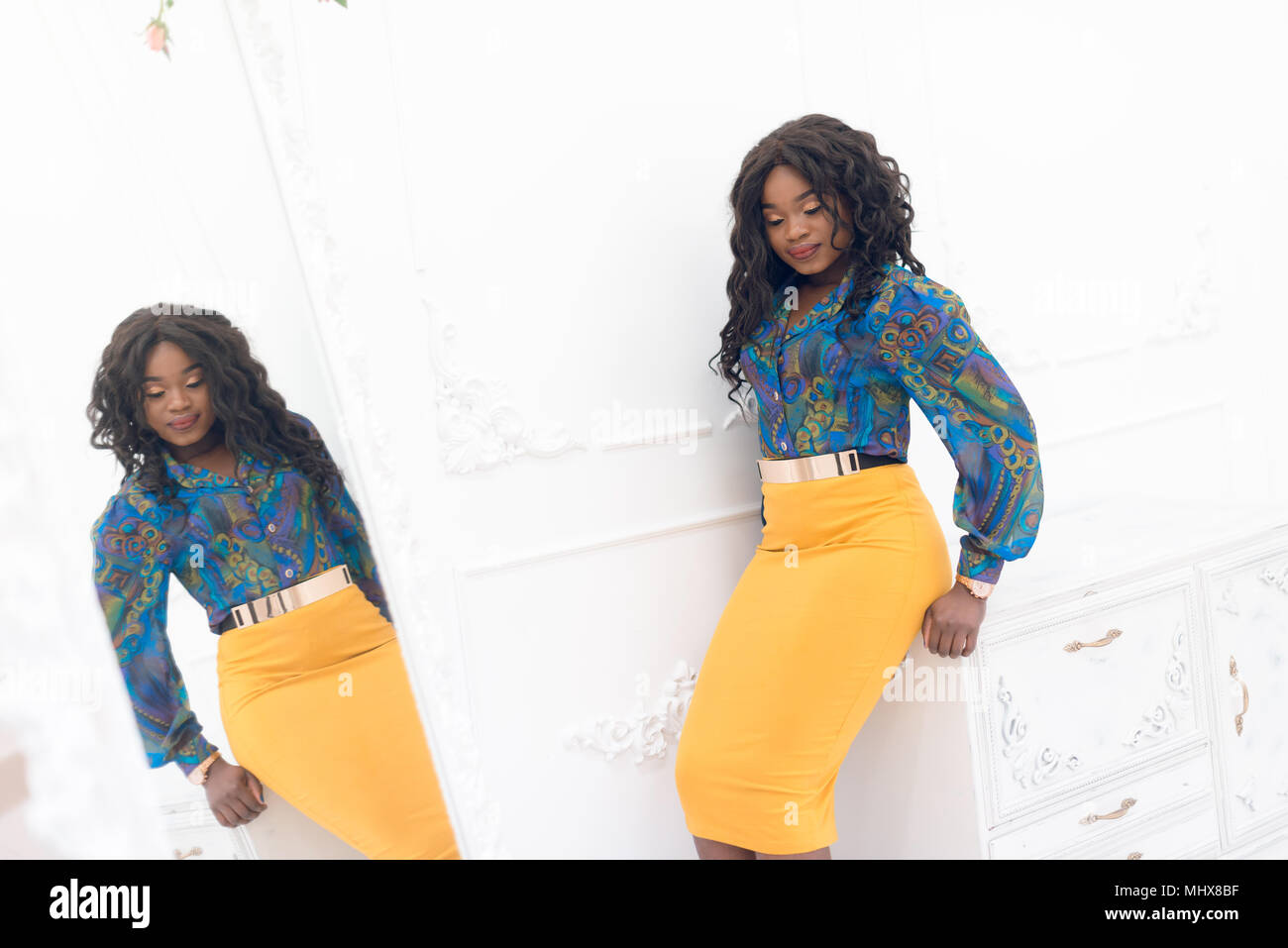 Beautiful young african american girl posing in studio, looking at ...