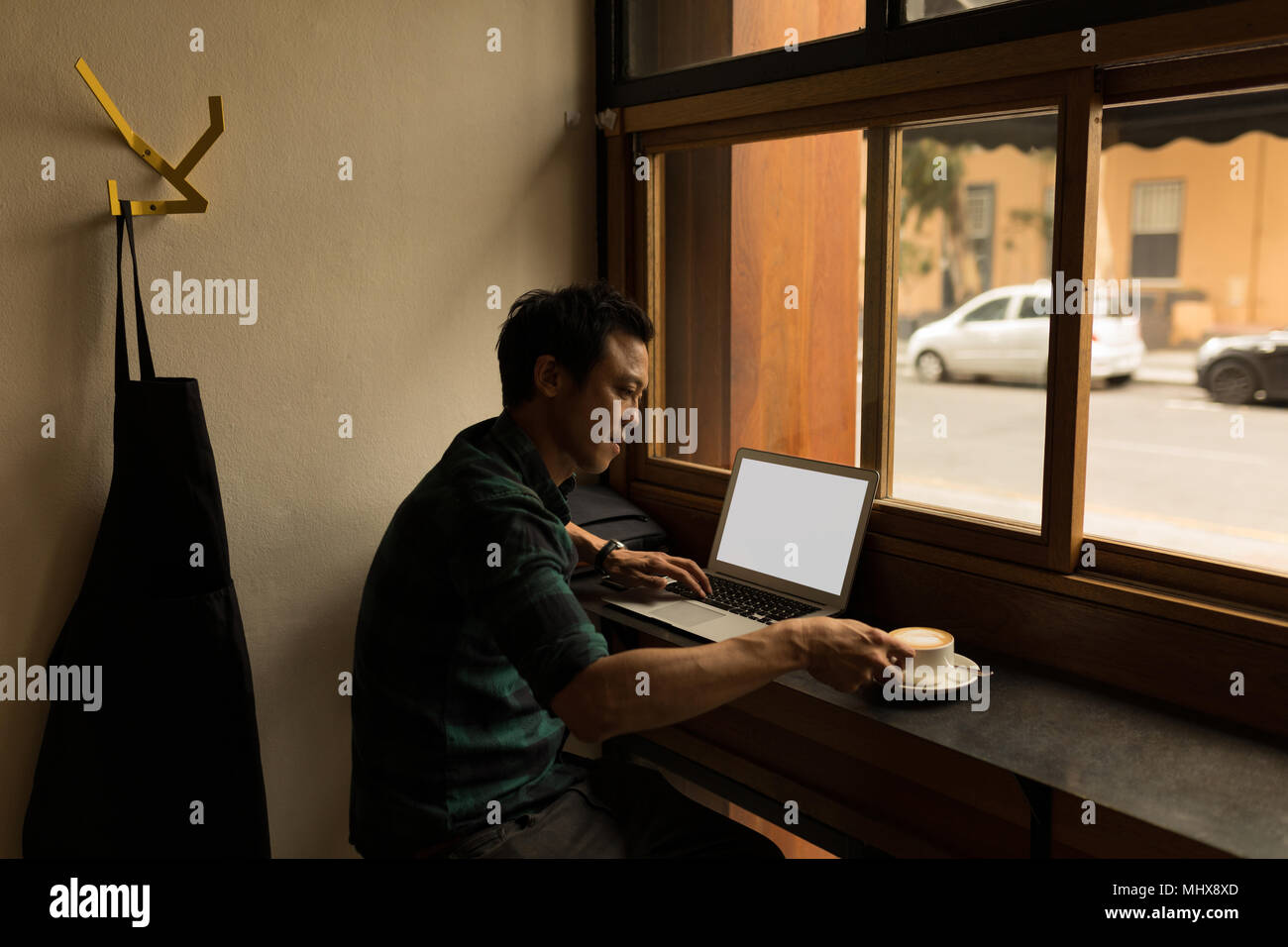 Businessman using laptop while having coffee Stock Photo