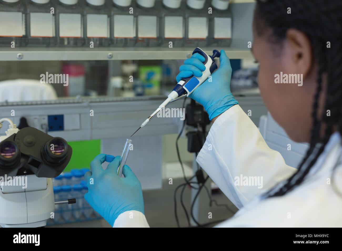 Scientist pipetting solution into the glass test tube Stock Photo