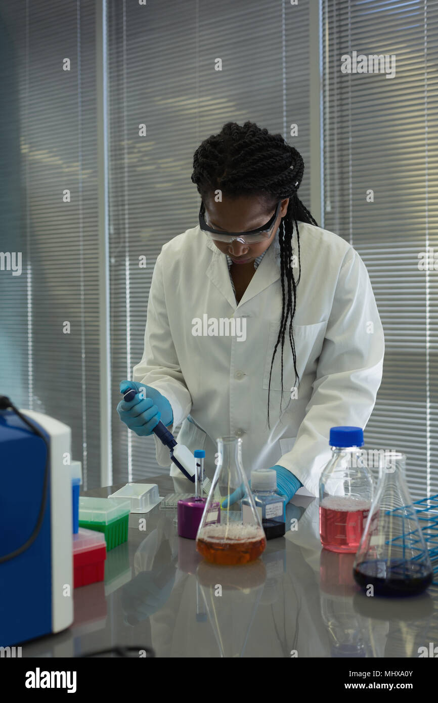 Scientist pipetting solution into the glass test tube Stock Photo