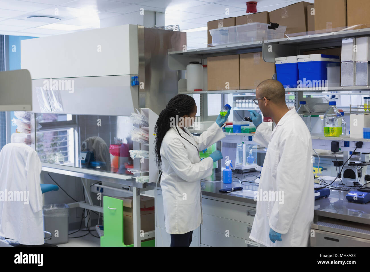 Scientists discussing over chemical solution in bottle Stock Photo