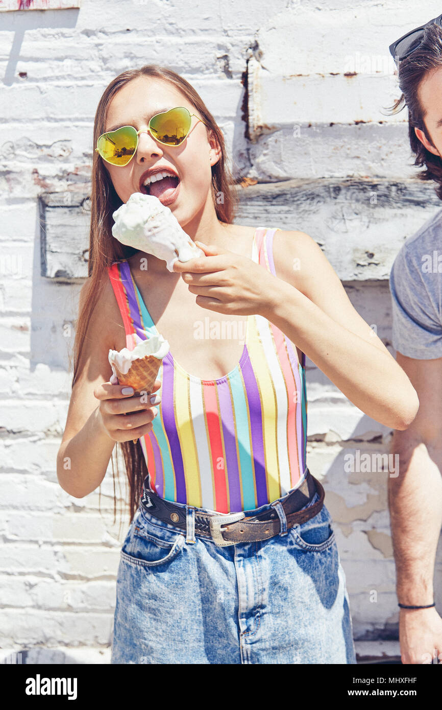 Young women eating melting ice cream cone Stock Photo