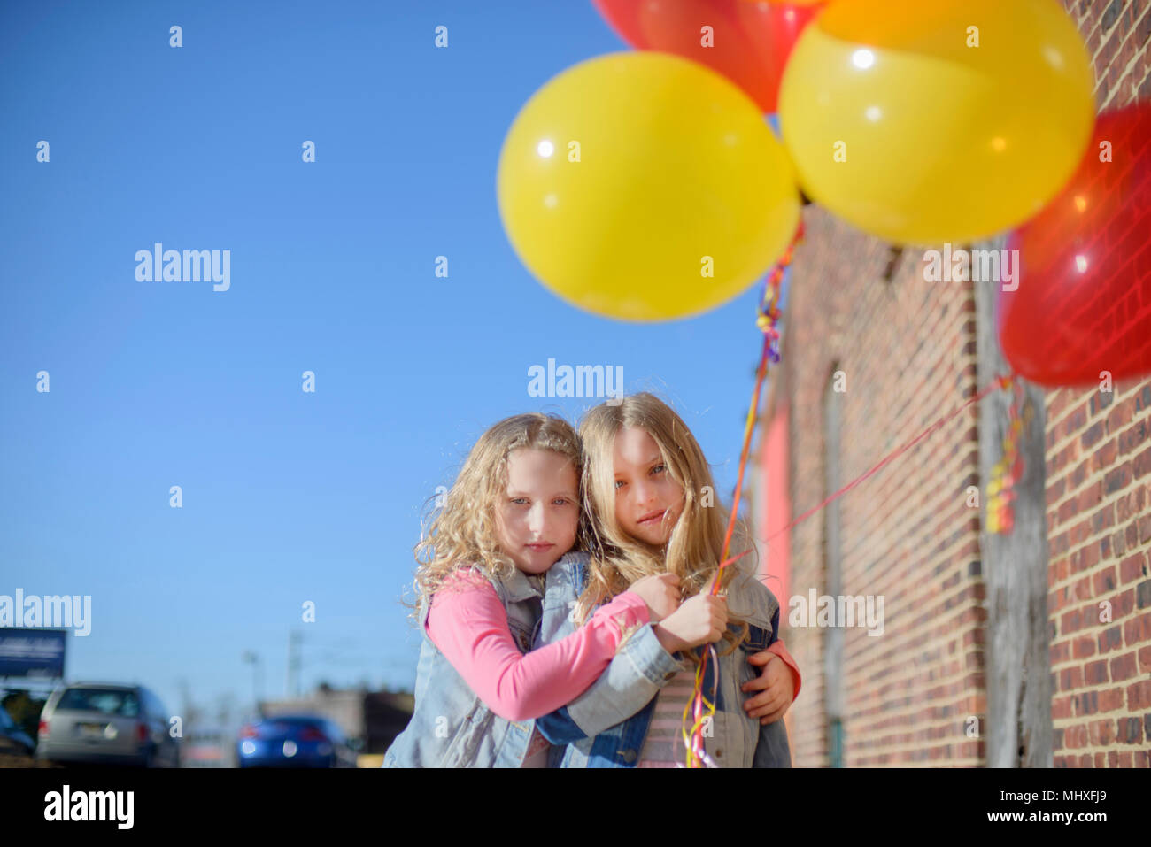 Two sisters with bunch of colourful balloons, portrait Stock Photo