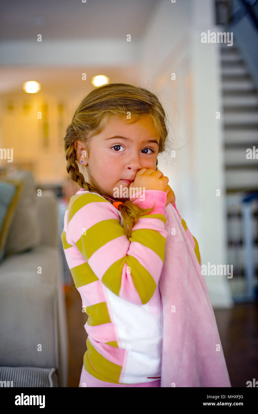 Girl with comfort blanket in living room at bedtime, portrait Stock Photo