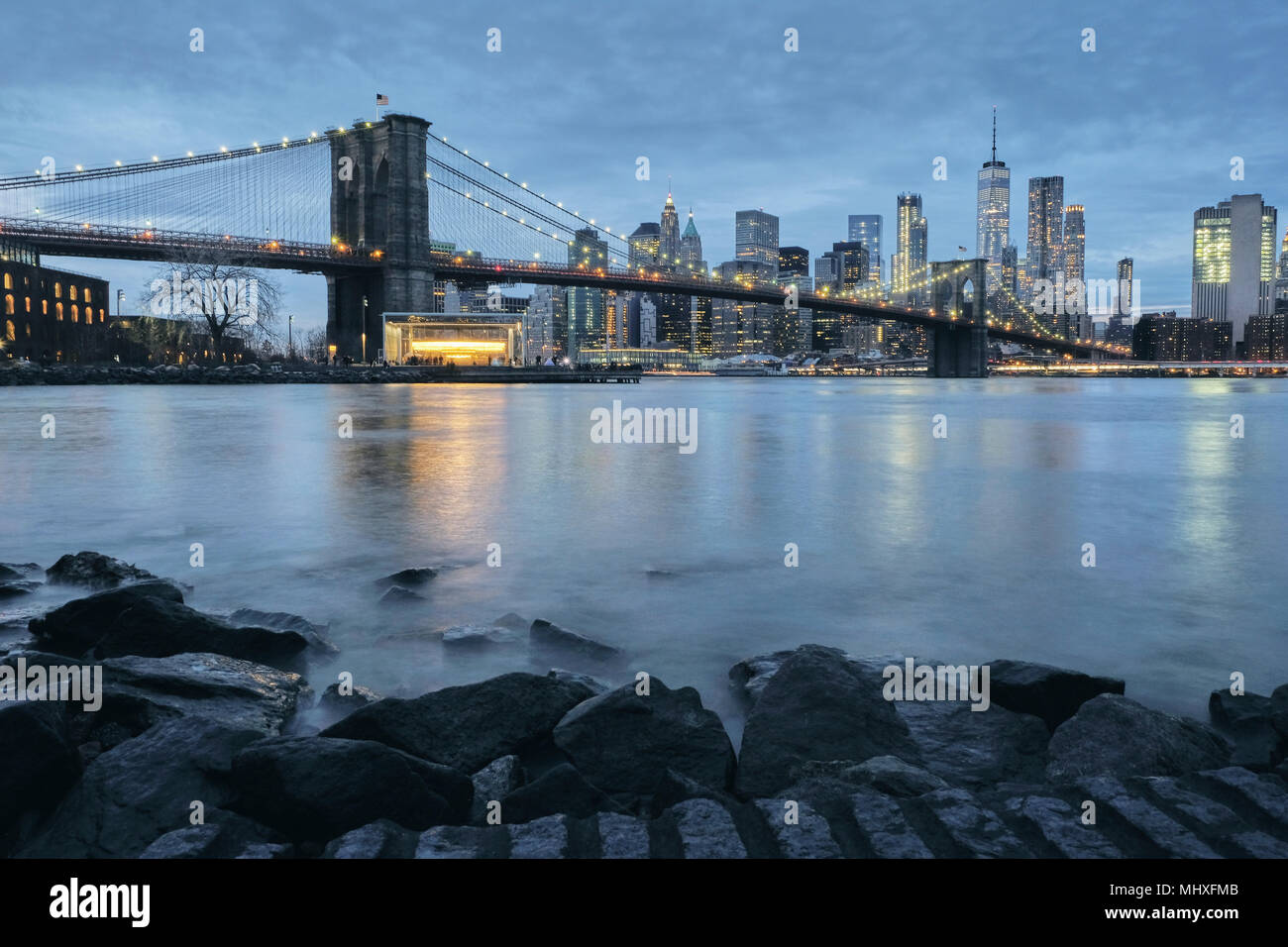 Cityscape with Brooklyn Bridge and Lower Manhattan skyline at dusk, New York, USA Stock Photo
