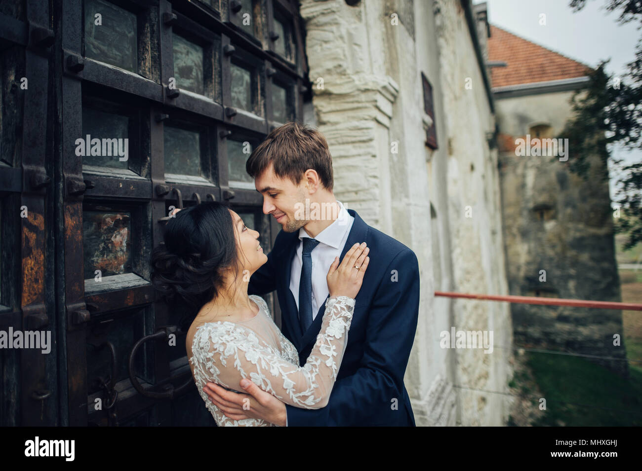 Asian bride with groom posing in front of old antique door Stock Photo ...