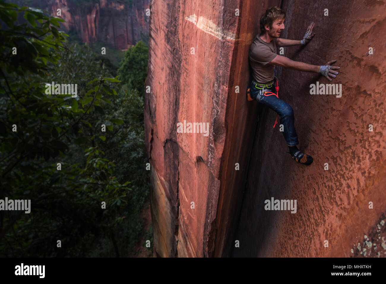 Rock climber climbing sandstone rock, elevated view, Liming, Yunnan