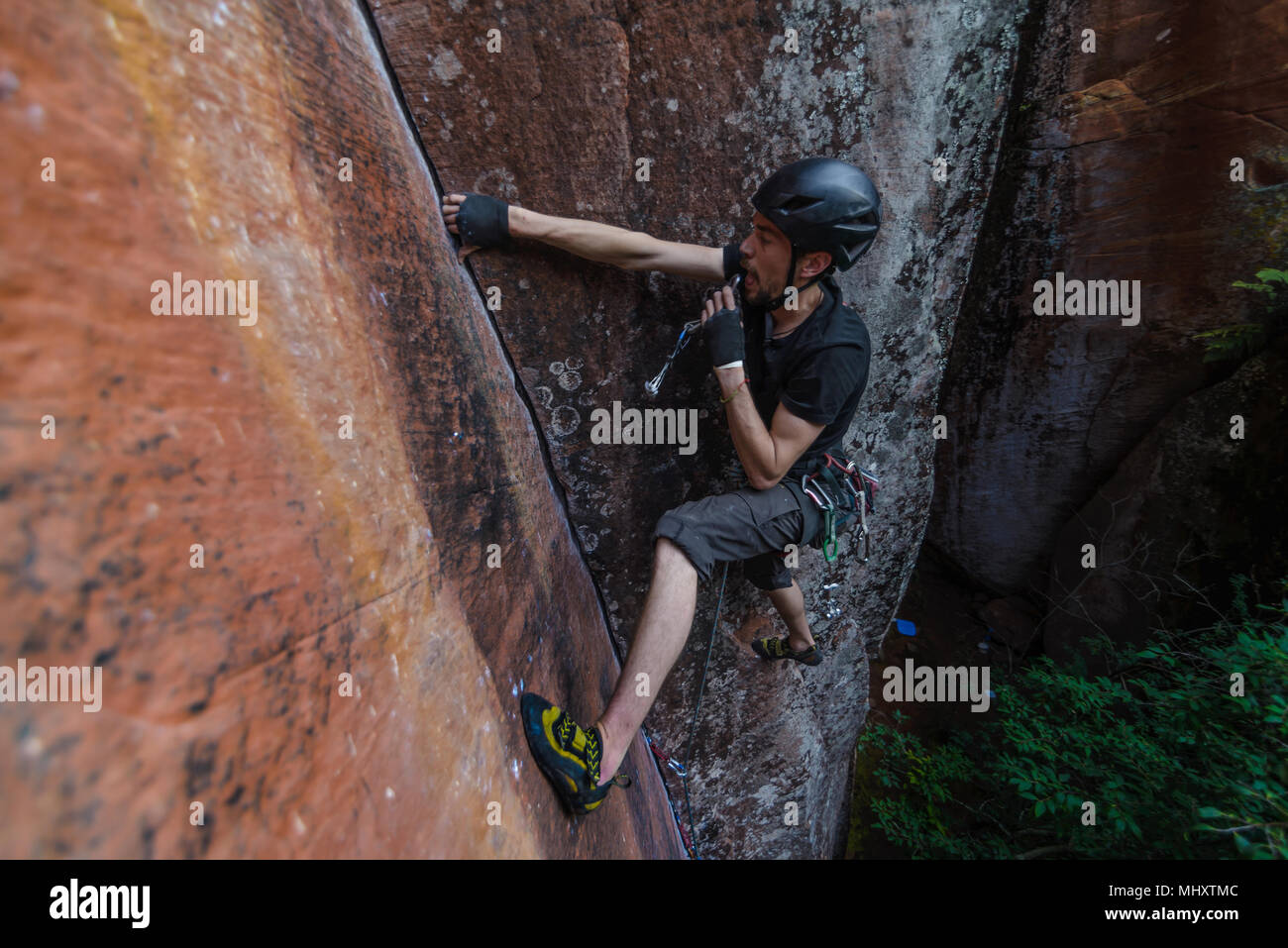 Rock climber climbing sandstone rock, elevated view, Liming, Yunnan Province, China Stock Photo