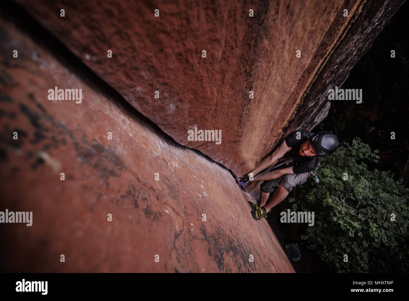 Rock climber climbing sandstone rock, overhead view, Liming, Yunnan