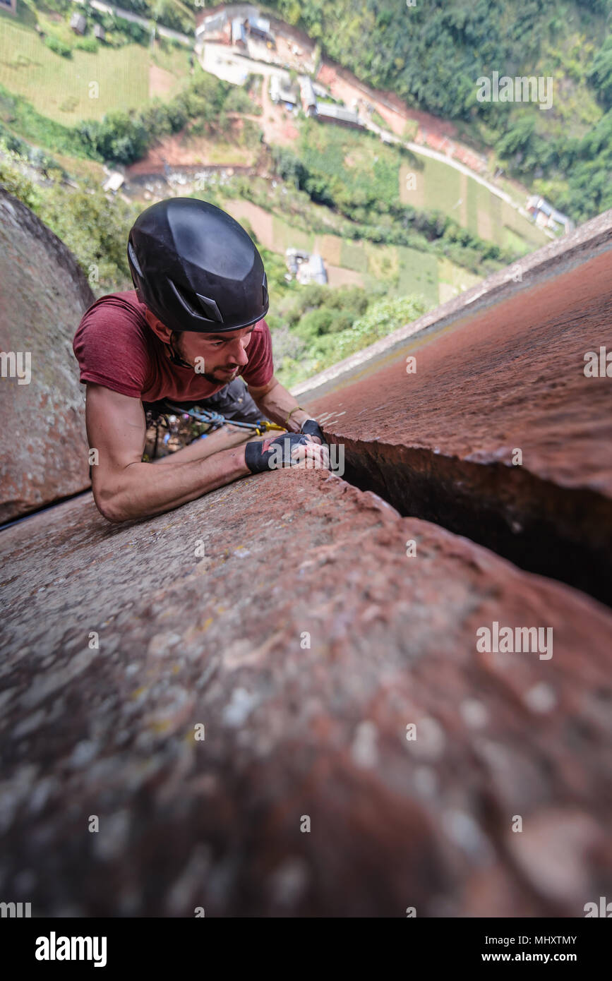 Rock climber climbing sandstone rock, overhead view, Liming, Yunnan Province, China Stock Photo