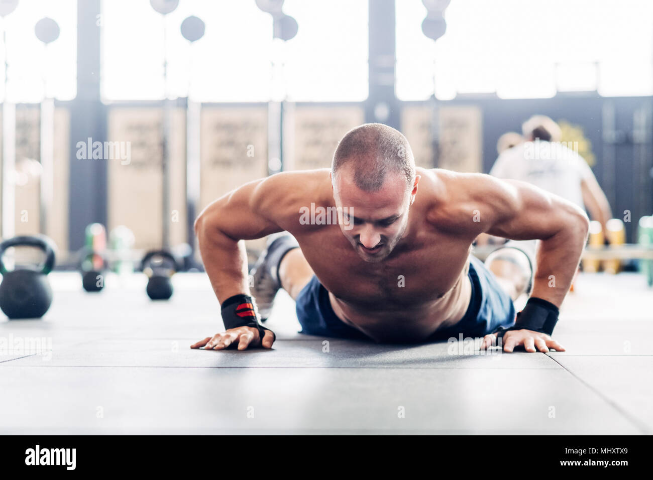 Man doing pushup in gym Stock Photo