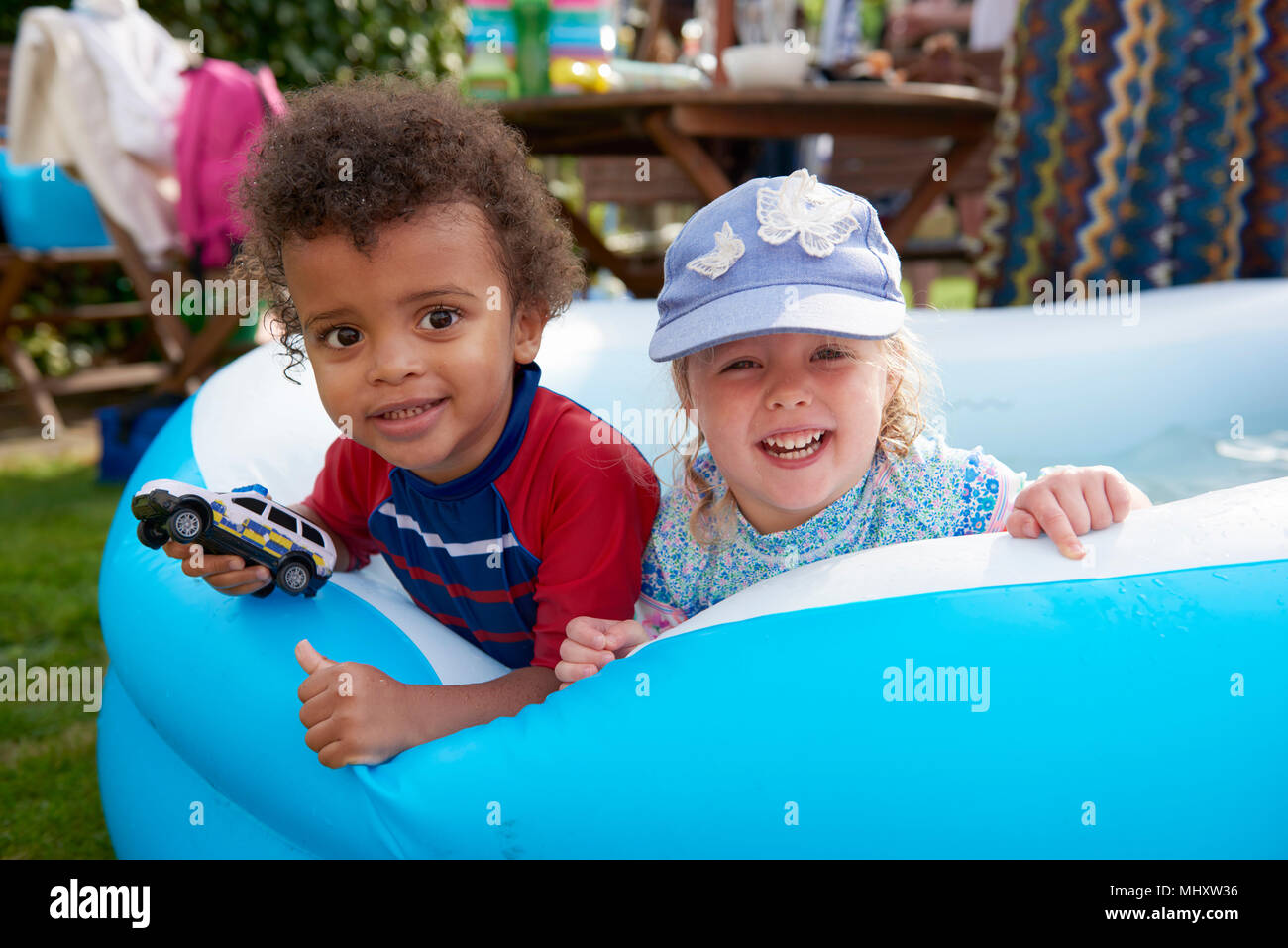 Two toddlers playing in paddling pool, portrait Stock Photo
