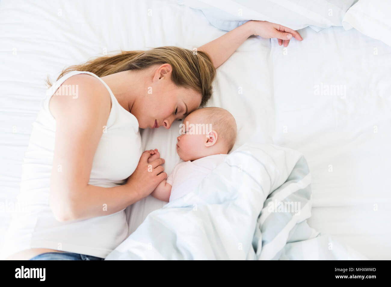 Mother and baby asleep in bed Stock Photo