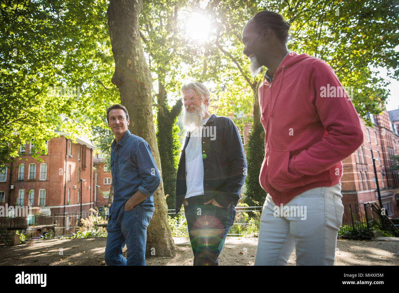 Three mature men walking in street Stock Photo