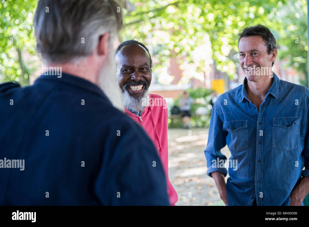 Three mature men, outdoors, talking Stock Photo