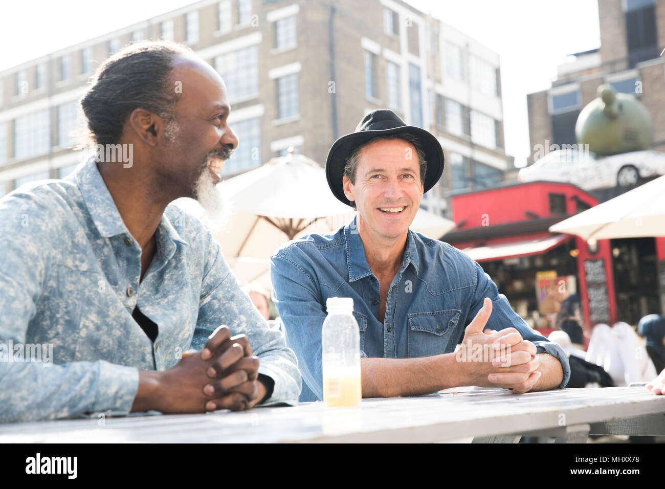 Friends chatting at food market, London, UK Stock Photo