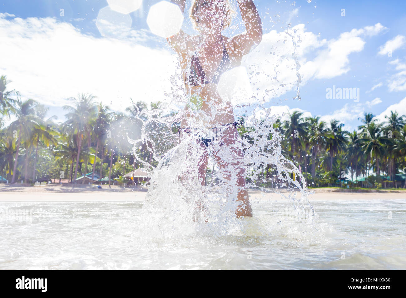 Woman splashing in sea, low angle view, Nacpan Beach, Palawan, Philippines Stock Photo
