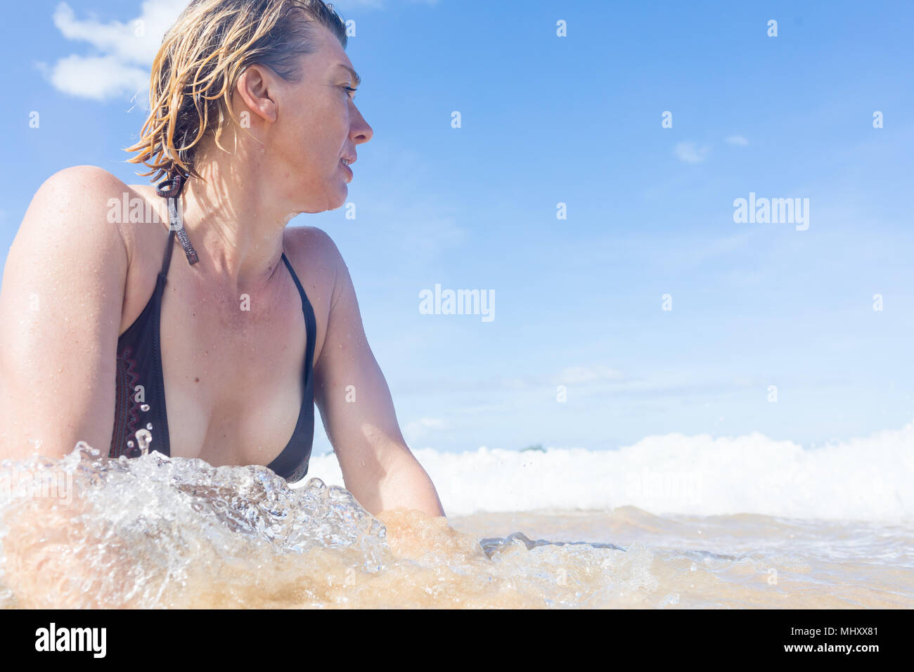 Woman in sea, looking away, low angle view, Nacpan Beach, Palawan, Philippines Stock Photo