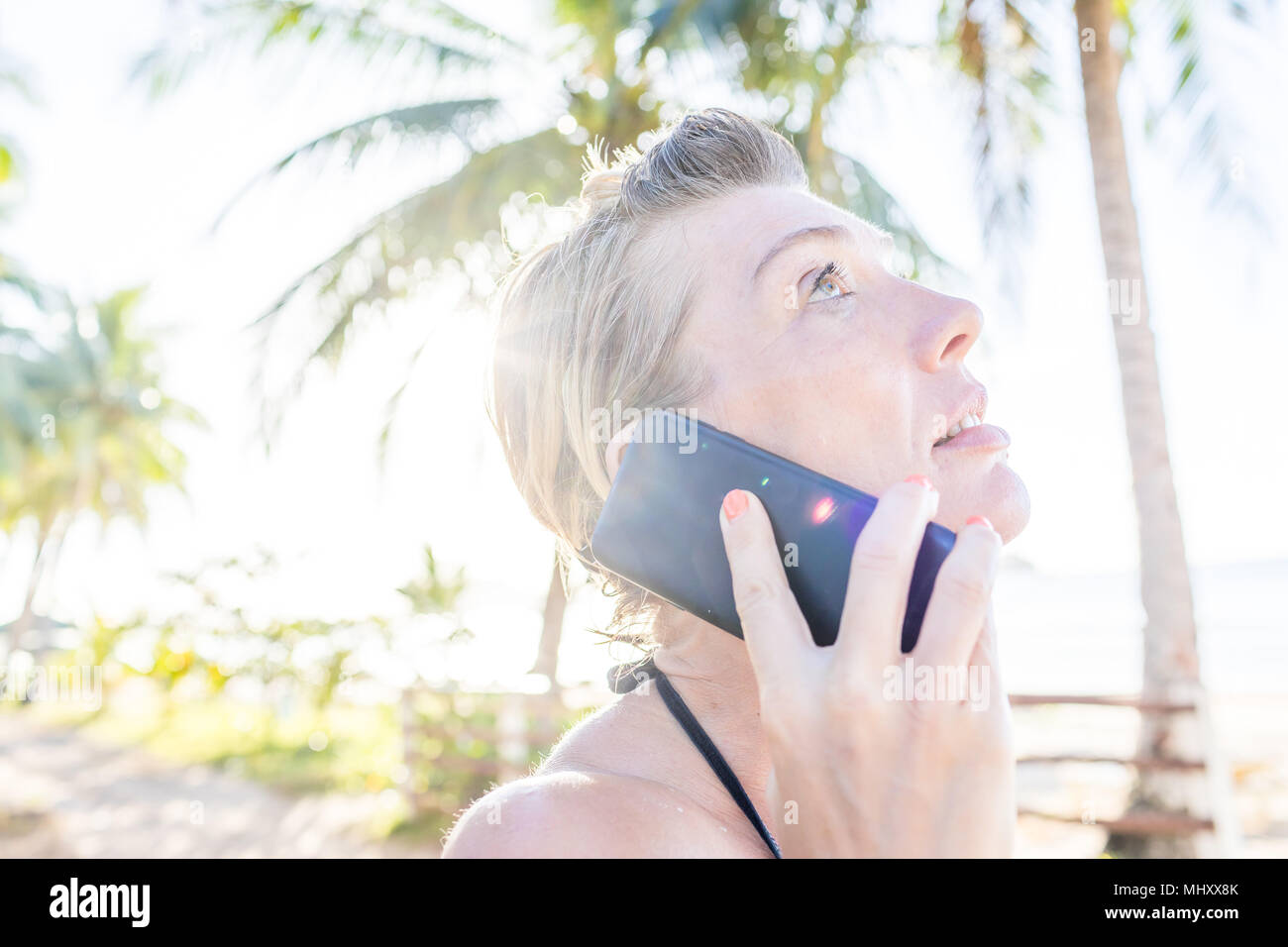 Woman on beach, using smartphone, close-up, Nacpan Beach, Palawan, Philippines Stock Photo