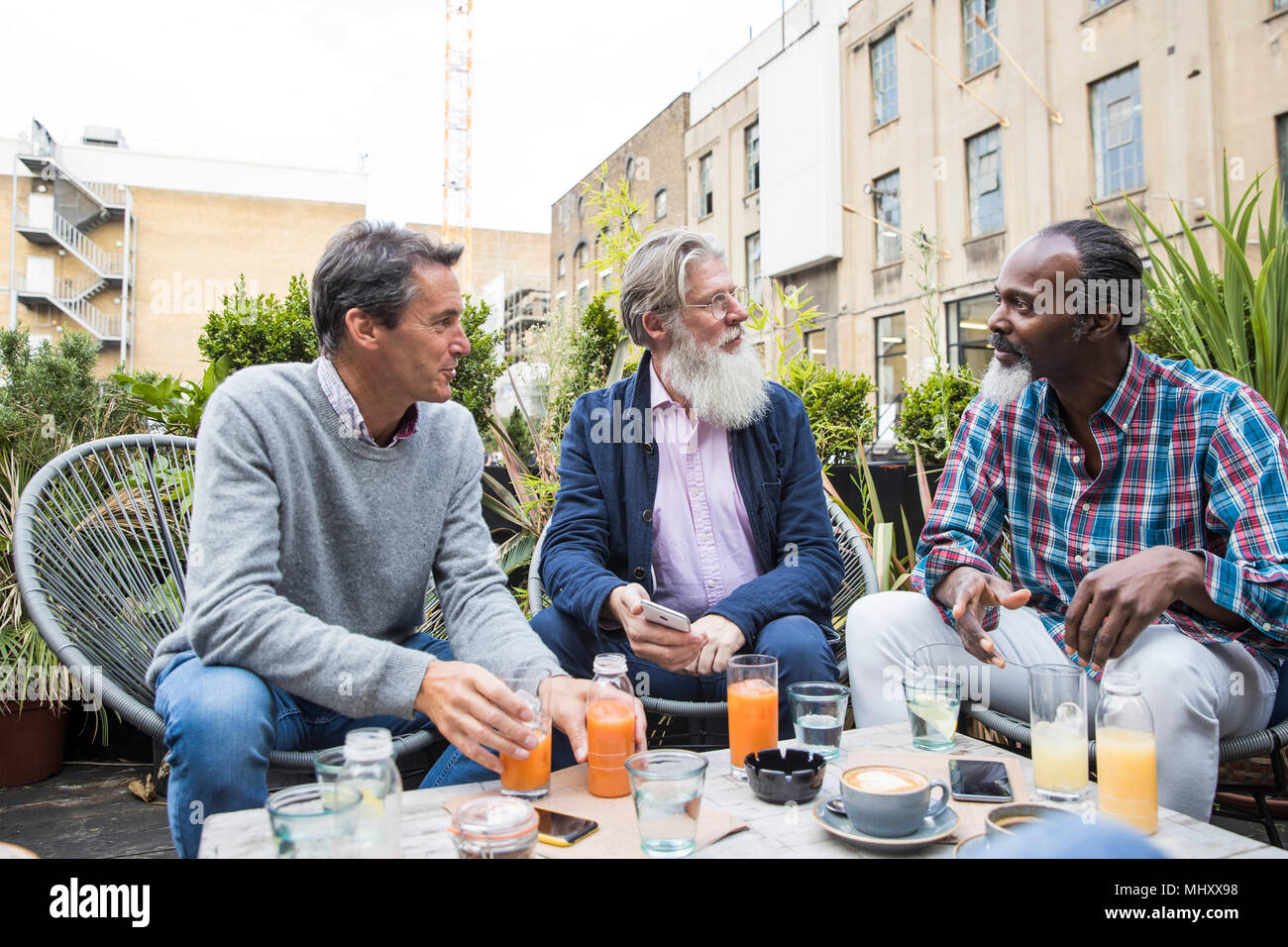 Friends chatting over drinks outdoors, London, UK Stock Photo