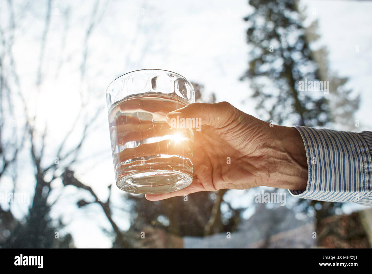 Senior woman holding glass of water, close-up Stock Photo