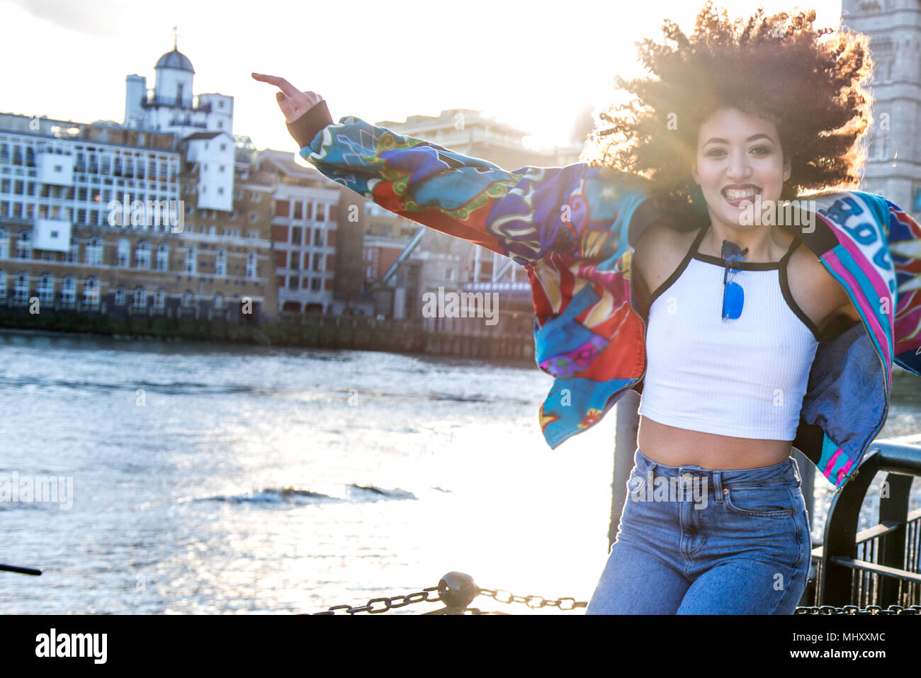 Portrait of young woman outdoors, jumping for joy, London, England, UK Stock Photo