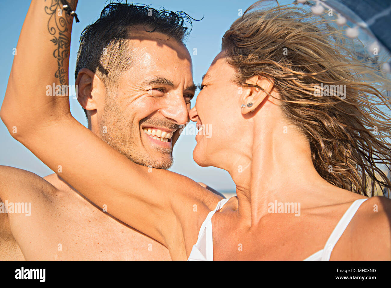 Mature couple on beach, face to face, smiling Stock Photo