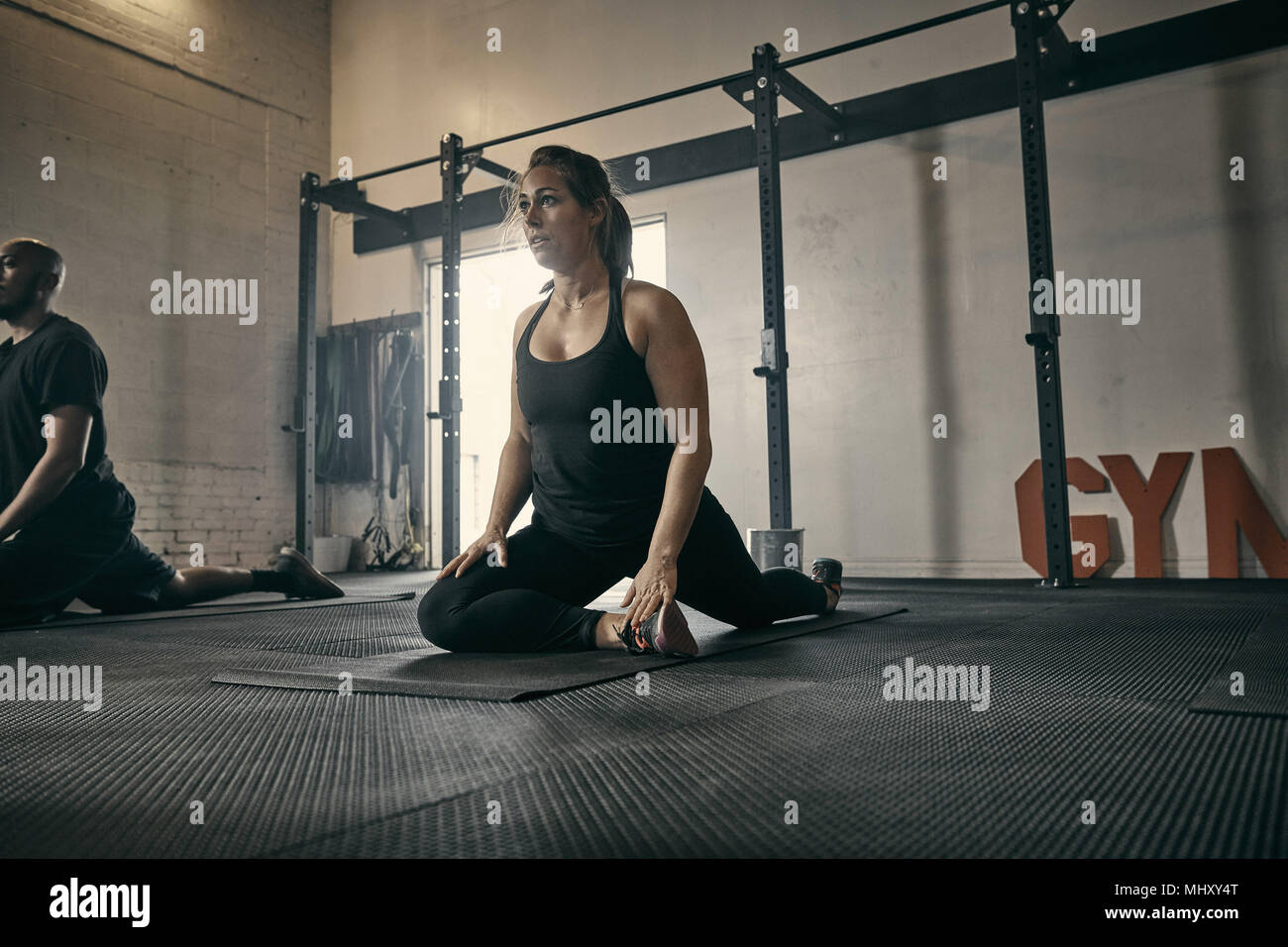 Woman in yoga position in gym Stock Photo
