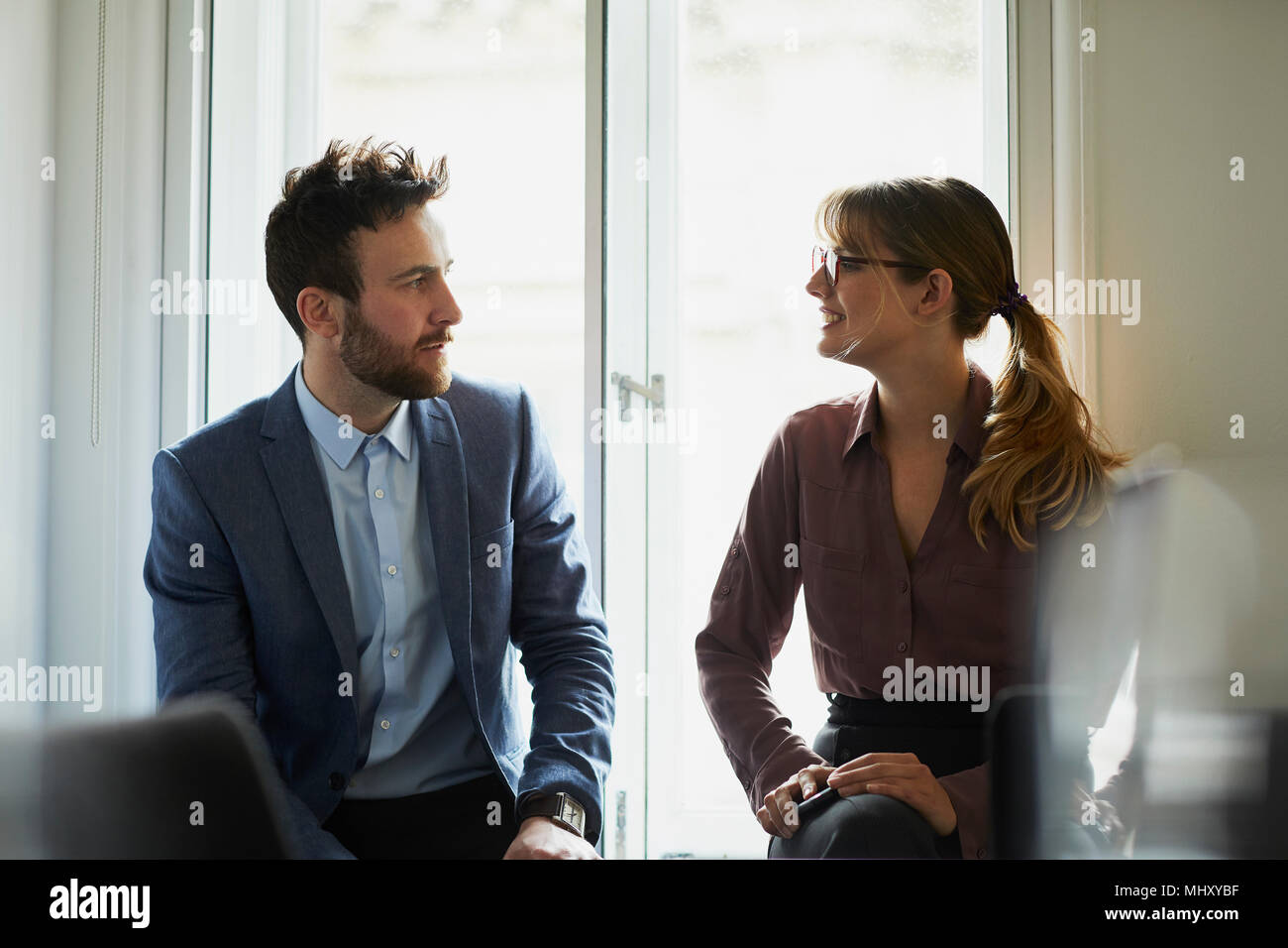 Colleagues chatting in office Stock Photo