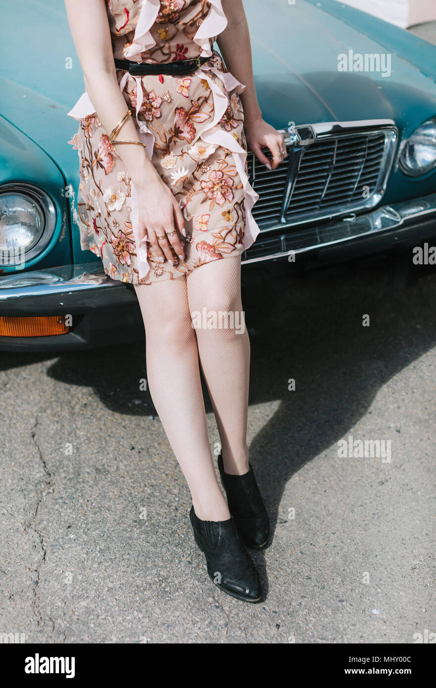 Cropped view of woman leaning against vintage car Stock Photo