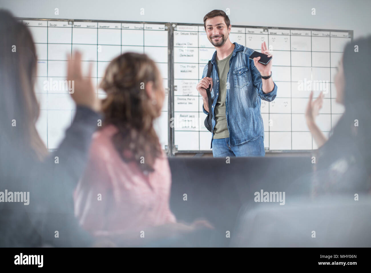 Young man greeting colleagues in office Stock Photo