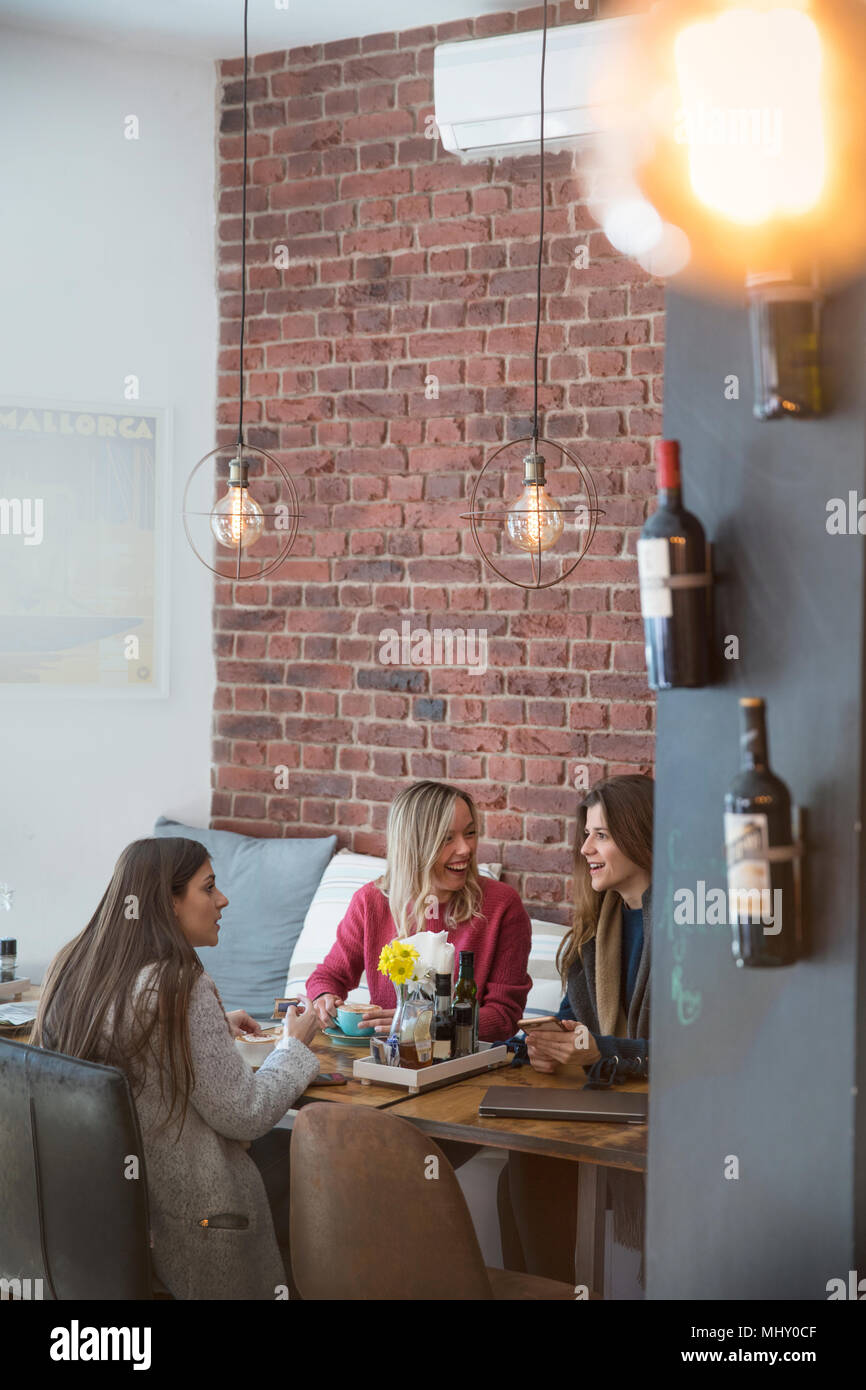 Three female friends, sitting together in cafe Stock Photo