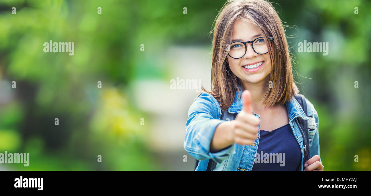 Attractive young teenage schoolgirl showing thumbs up Stock Photo - Alamy