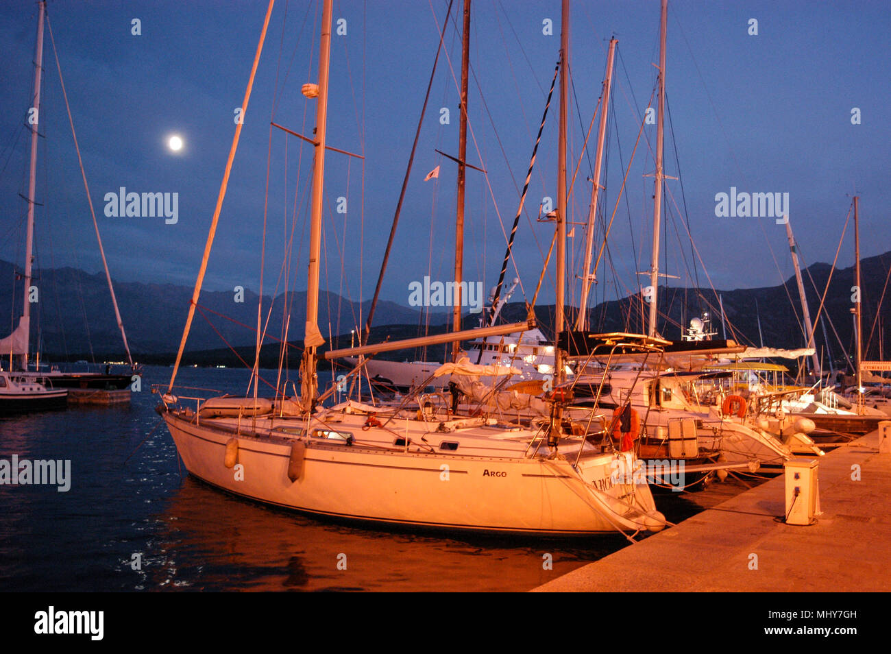 The moon over Calvi Bay and moored seagoing yachts in Calvi marina along the Quai Adolphe