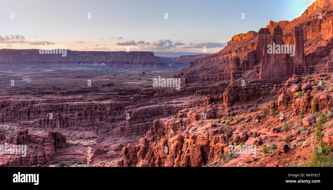 Fisher Towers rock formations rise above the Colorado River in Professor Valley in the late afternoon sun near Moab, Utah. Stock Photo