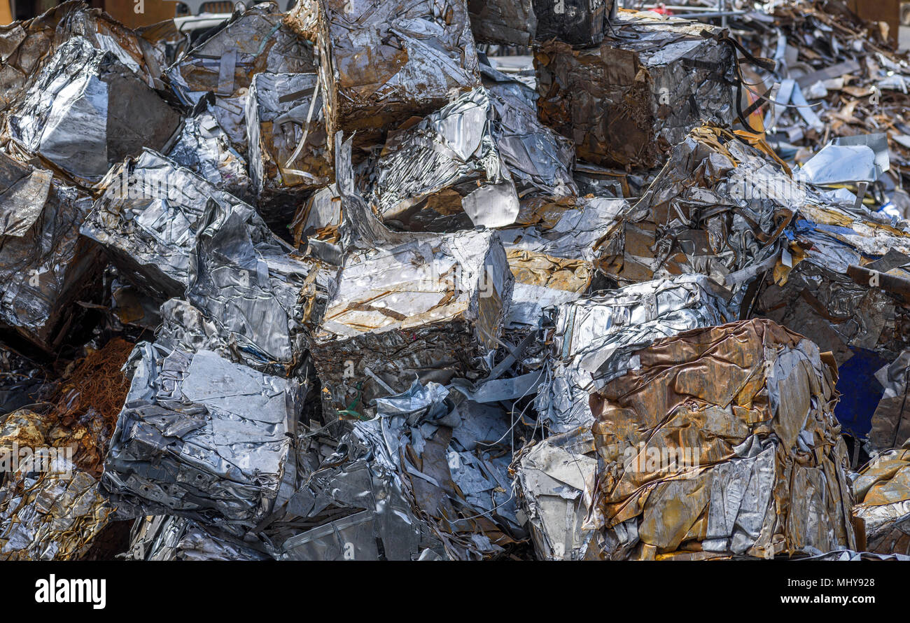 Scrap metal waste pressed into blocks at a processing plant. Stock Photo
