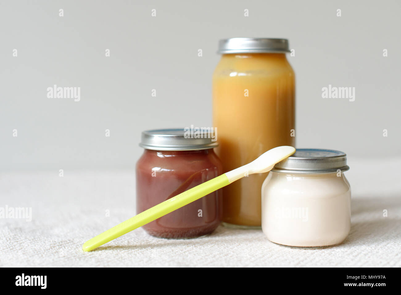 Bowls of pureed food with spoon for baby over blurred background Stock Photo