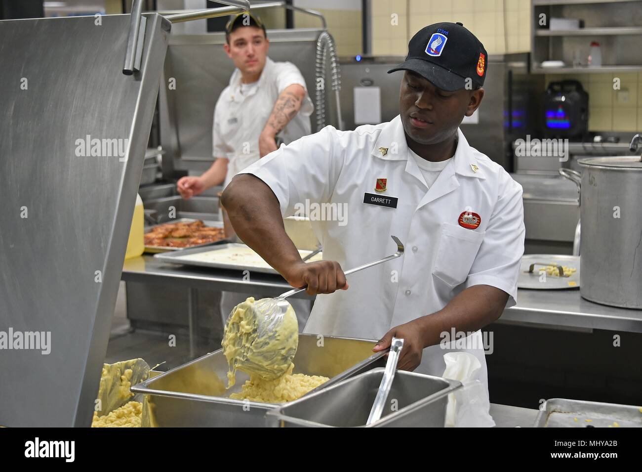 U.S. Army Sgt. Kareem Garrett, a culinary specialist with Fury Battery, 4th Battalion, 319th Airborne Field Artillery Regiment, 173rd Airborne Brigade, fills a pan at the Tower Barracks Dining Facility, Grafenwoehr, Germany, May 3, 2018, May 3, 2018. (U.S. Army photo by Gertrud Zach). () Stock Photo
