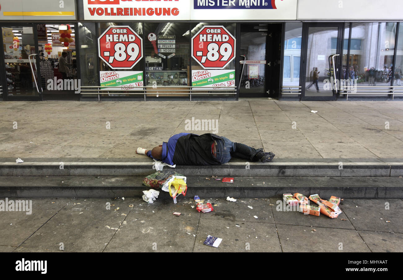 Berlin Germany September 6th 2009 Homeless Man Sleeping On A Sidewalk At Alexanderplatz Amidst Garbage In Front Of Closed Shops Stock Photo Alamy