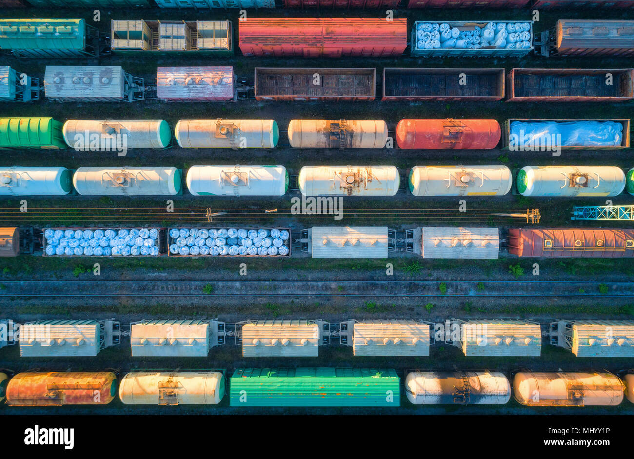 Aerial view of railway wagons. Cargo trains. Top view of colorful freight train on the railway station. Wagons with goods on railroad. Heavy industry. Stock Photo